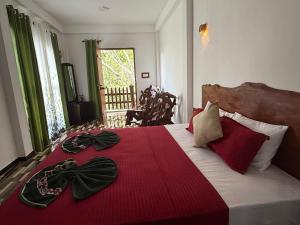 a bedroom with a large bed with a red blanket at Mango tree ella in Ella