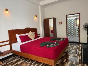 a bedroom with a large bed with a red blanket at Mango tree ella in Ella