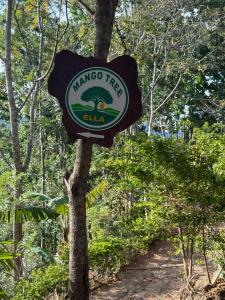 a sign on a tree next to a trail at Mango tree ella in Ella