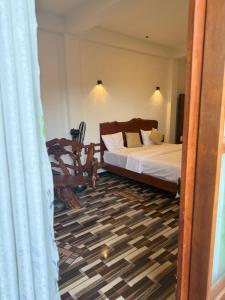 a bedroom with a bed and a chair in it at Mango tree ella in Ella