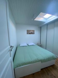 une chambre avec un lit et une lucarne dans l'établissement Petite maison cosy proche de La Défense, à Nanterre