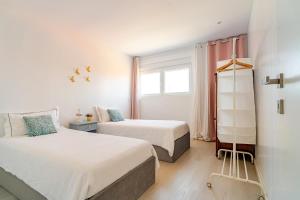 a bedroom with two beds and a window at Vegan Pátio - Douro e Ribeira in Bandeira