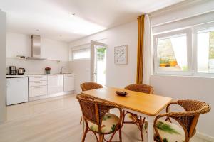 a kitchen and dining room with a wooden table and chairs at Vegan Pátio - Douro e Ribeira in Bandeira