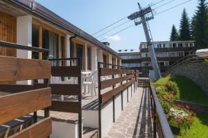 マリッレーヴァにあるResidence Abeteの木製のベンチ付きの建物のバルコニー