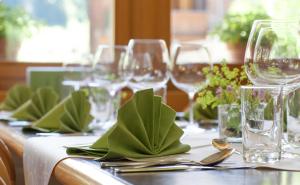 a table with wine glasses and green napkins at Hotel Edelweiss in Wengen
