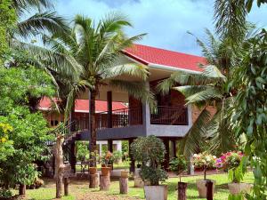 a house with palm trees in front of it at Baantientong in Krabi town