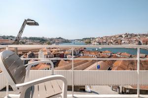 a balcony with a chair and a view of a city at Vegan Apartment - Porto e Douro in Bandeira