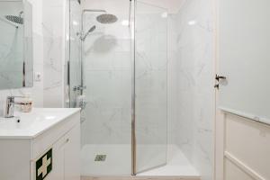 a white bathroom with a shower and a sink at Vegan Apartment - Porto e Douro in Bandeira +22 photos