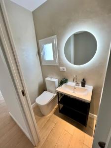 ein Badezimmer mit Toilette, Waschbecken und Spiegel in der Unterkunft Apartamento Santa Cruz de Tenerife in La Cuesta
