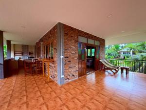 an open living room with a brick wall and a table at Baantientong in Krabi town
