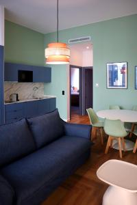 a living room with a blue couch and a table at Aparthotel Casa Fages in Figueres