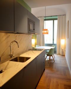 a kitchen with a sink and a table in a room at Aparthotel Casa Fages in Figueres