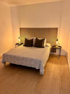 ein Schlafzimmer mit einem Bett mit zwei Tischen und zwei Lampen in der Unterkunft Apartamento Acogedor Santa Cruz in La Cuesta