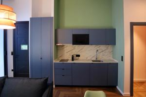 a kitchen with blue cabinets and a sink at Aparthotel Casa Fages in Figueres +67 photos