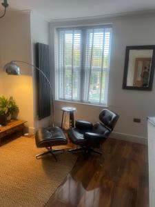 a living room with two chairs and a table at Luxury apartment with 2-Beds in Beckenham