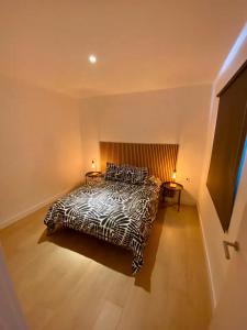 ein Schlafzimmer mit einem schwarzen und weißen Bett mit zwei Lampen in der Unterkunft Encantador Apartamento Familiar in La Cuesta