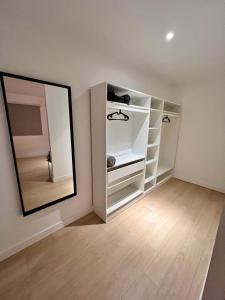 ein Zimmer mit einem Spiegel und weißen Regalen in der Unterkunft Encantador Apartamento Familiar in La Cuesta