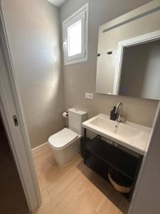 ein Badezimmer mit Toilette, Waschbecken und Spiegel in der Unterkunft Encantador Apartamento Familiar in La Cuesta