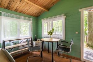 a green room with a table and chairs at Slėnis Trakuose in Trakai