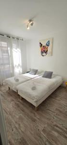 two beds in a room with white walls at T2 du Sanctuaire 400 m de la grotte Lourdes wifi TV in Lourdes