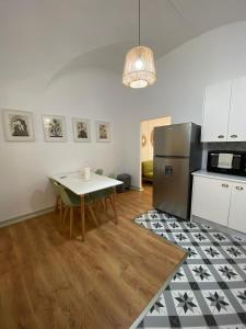 a kitchen with a table and a refrigerator at Casa do Convento in Évora +15 photos