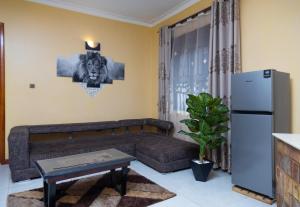 a living room with a couch and a refrigerator at A&z apartments in Namulanda