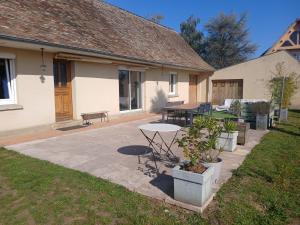 a patio with a table and chairs in a yard at Bienvenue à la maison ! in Mulsanne