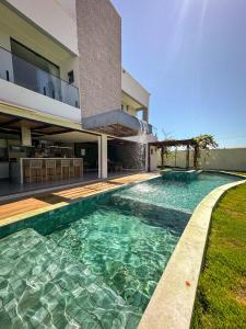 a swimming pool in front of a house at Casa Som das Ondas in Fortim