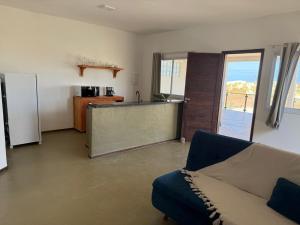 a living room with a couch and a kitchen at Apartamentos Ventos da Sibauma in Tibau do Sul