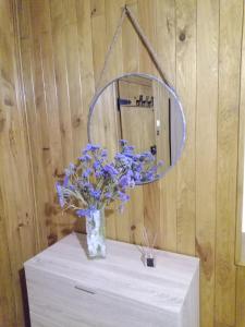Un jarrón de flores azules sobre una mesa con un espejo. en Sobreirinha, en Coruche