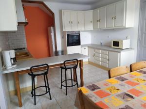 a kitchen with a table and chairs and a counter top at Gîte convivial avec 3 chambres, proche du patrimoine historique, cour et équipements inclus - FR-1-589-38 in Aouze