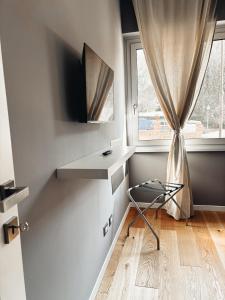a small white room with a window and a chair at VB's Luxury Flat in Rome +14 photos
