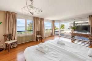 a bedroom with a large white bed and a large window at Villa heart of Evian swimming pool in Évian-les-Bains +33 photos