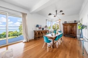 a dining room with a table and chairs and a large window at Villa heart of Evian swimming pool in Évian-les-Bains
