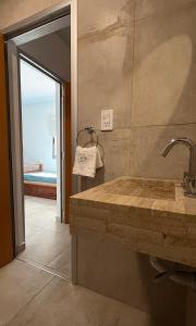 a bathroom with a large stone sink in a room at Carmel Apart Paraná in Paraná +87 photos