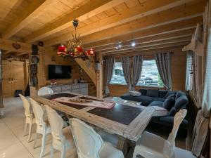a dining room with a table and a couch at Chalet Neuf Haut de Gamme avec Spa, Sauna et Décoration Originale – Gérardmer - FR-1-589-80 in Gérardmer