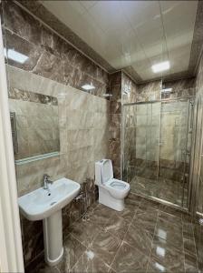 a bathroom with a toilet and a sink and a shower at 2-Bedroom Apartment in Sumqayyt +11 photos