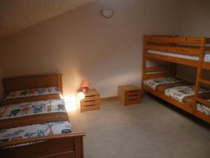 a bedroom with two bunk beds and a lamp at Gîte rénové avec grand terrain, proche d'Épinal, idéal pour balades et familiales - FR-1-589-87 in Dommartin-aux-Bois