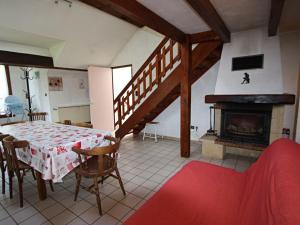 Un comedor con mesa y chimenea. en Gîte rénové, nature et jeux près du Val d'Ajol, 3 ch, 2 sdb, Wifi, équipements bébé, proche ski - FR-1-589-113, en Girmont-Val-dʼAjol