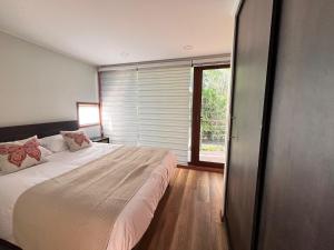 Ketrawe Townhouse في بوكون: غرفة نوم بسرير كبير ونافذة