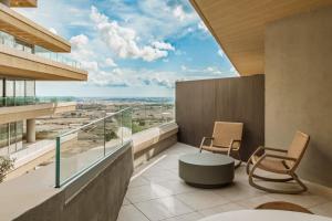 a balcony with two chairs and a table on a building at AX The Heights Residences - Adults Only in Ħal-Bajjada