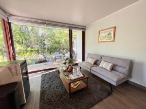a living room with a couch and a television at Ketrawe Townhouse in Pucón