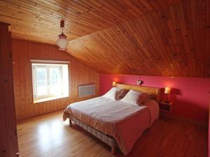 ein Schlafzimmer mit einem großen Bett mit einer roten Wand in der Unterkunft Gîte de montagne rénové avec poêle à bois - Saulxures-sur-Moselotte - FR-1-589-237 in Saulxures-sur-Moselotte