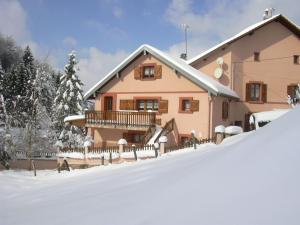 a house with a snow covered yard in front of it at Gîte familial avec piscine, idéal pour randonnées et pêche, proche Gérardmer et crêtes vosgiennes - FR-1-589-238 in Vienville