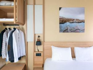 a bedroom with a bed and a wardrobe at IBIS STYLES Rouen Parc Expos Zenith in Saint-Étienne-du-Rouvray