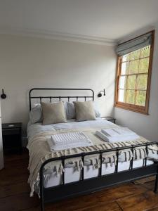 1 cama en un dormitorio blanco con ventana en Old Palace Lane Richmond, en Richmond