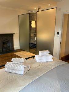 3 toallas están apiladas en la parte superior de una cama en Old Palace Lane Richmond, en Richmond