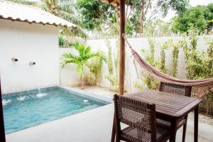 a patio with a hammock and a swimming pool at Pousada Vilagoa in Coqueiro Sêco +24 photos