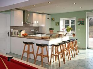 a kitchen with a island with bar stools at Ferme Vosgienne rénovée avec spa, sauna, jacuzzi, billard et étang privé en pleine nature - FR-1-589-327 in Saulxures-sur-Moselotte