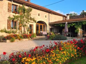 a building with a bunch of flowers in front of it at Charmant meublé au calme, proche cascades, randos, chevaux, parking et terrasse privée, WiFi gratuit - FR-1-589-365 in Le Tholy